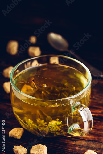 Cup of herbal tea with refined sugar