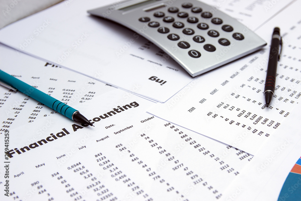 Financial accounting, Image a plurality of numbers on paper and calculator, Numbers on paper, a pen and a calculator, coins. Financial accounting, Image a plurality of numbers on paper and calculator, Numbers on paper, a pen and a calculator, coins.