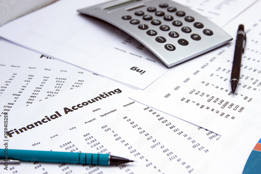 Financial accounting, Image a plurality of numbers on paper and calculator, Numbers on paper, a pen and a calculator, coins. Financial accounting, Image a plurality of numbers on paper and calculator, Numbers on paper, a pen and a calculator, coins.