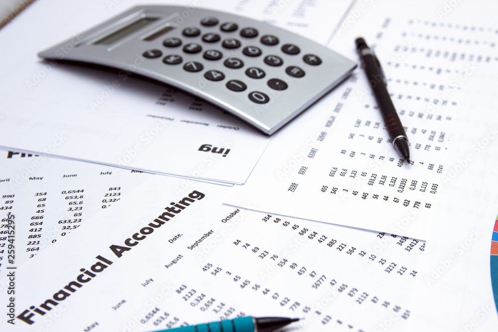 Financial accounting, Image a plurality of numbers on paper and calculator, Numbers on paper, a pen and a calculator, coins. Financial accounting, Image a plurality of numbers on paper and calculator, Numbers on paper, a pen and a calculator, coins.