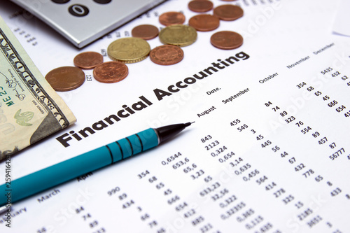 Financial accounting, Image a plurality of numbers on paper and calculator, Numbers on paper, a pen and a calculator, coins.