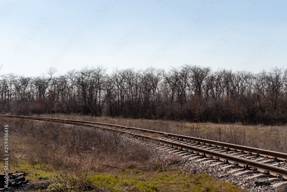 Railway track turning left among spring forests and fields