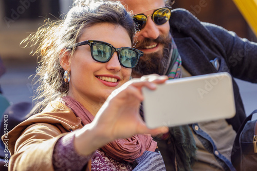 Smiling couple taking selfie with smartphone
