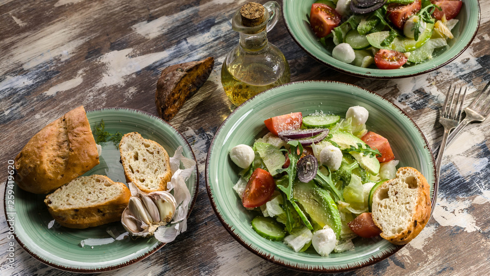 Food banner. Italian vegetable salad with avocado, cherry tomatoes, arugula and mozzarella cheese. Delicious and healthy food. Mediterranean Kitchen