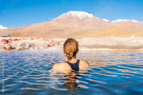 Woman taking a bath at El Tatio Geysers hot springs at Atacama desert, amazing thermal spring waters at 4500 masl inside Andes mountains scenic a place with an awe geothermal activity below the ground photo