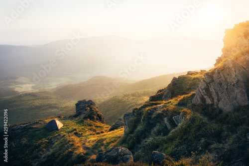 Sunset in the mountains over camping tent with warm light and beautiful view to mountains. Ukraine, mt. Pikuy photo