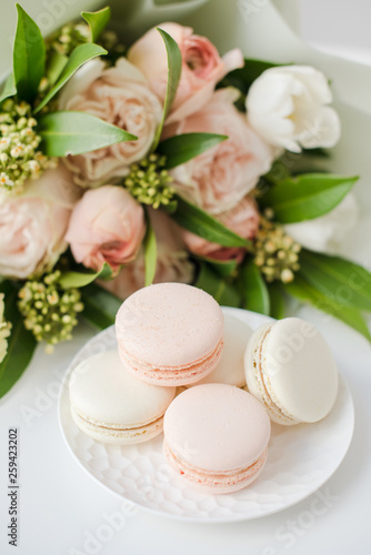 Elegant sweet macarons and pastel colored beige flowers