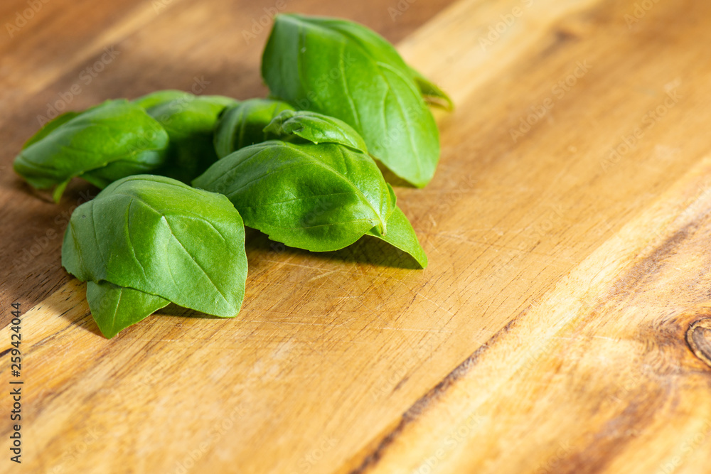 Fresh organic basilic leaves on a wooden surface. Fresh organic basilic leaves on a wooden surface.