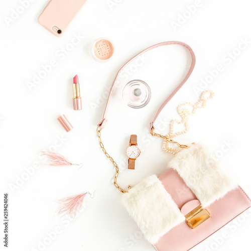 Women's pink bag with fashion trendy accessories: watch, perfume, phone, lipstick, earrings on white background. Flat lay, top view © K.Decor