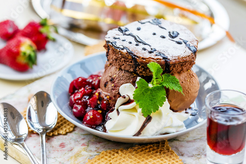 Fresh chocolate ice cream with brownie and cherry jam