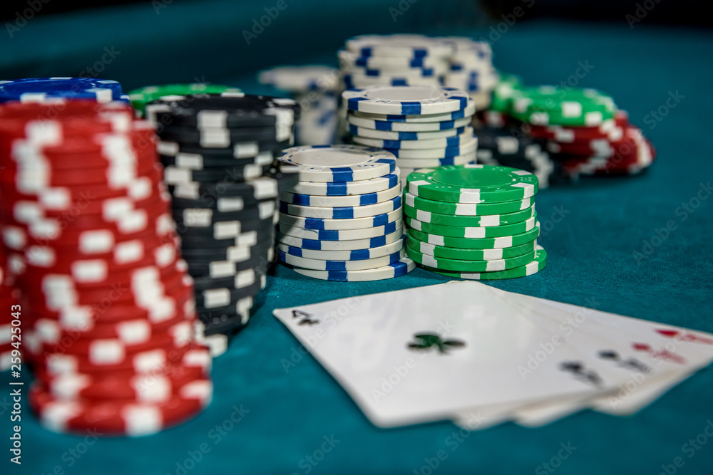 Poker chips with four aces at table in casino