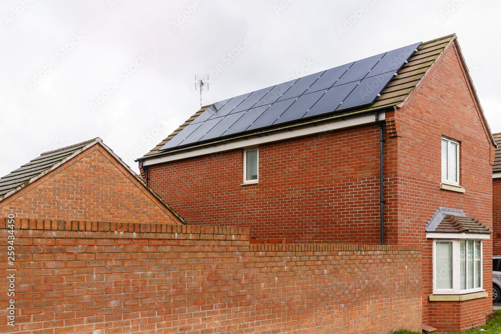 Solar photovoltaic panels mounted on a tiled new familiy houses roof, England