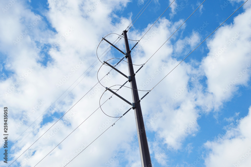 Fototapeta premium power lines and pole against blue sky and clouds