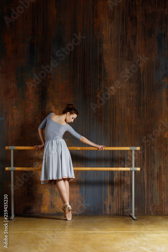 Young beautiful ballerina is posing in studio