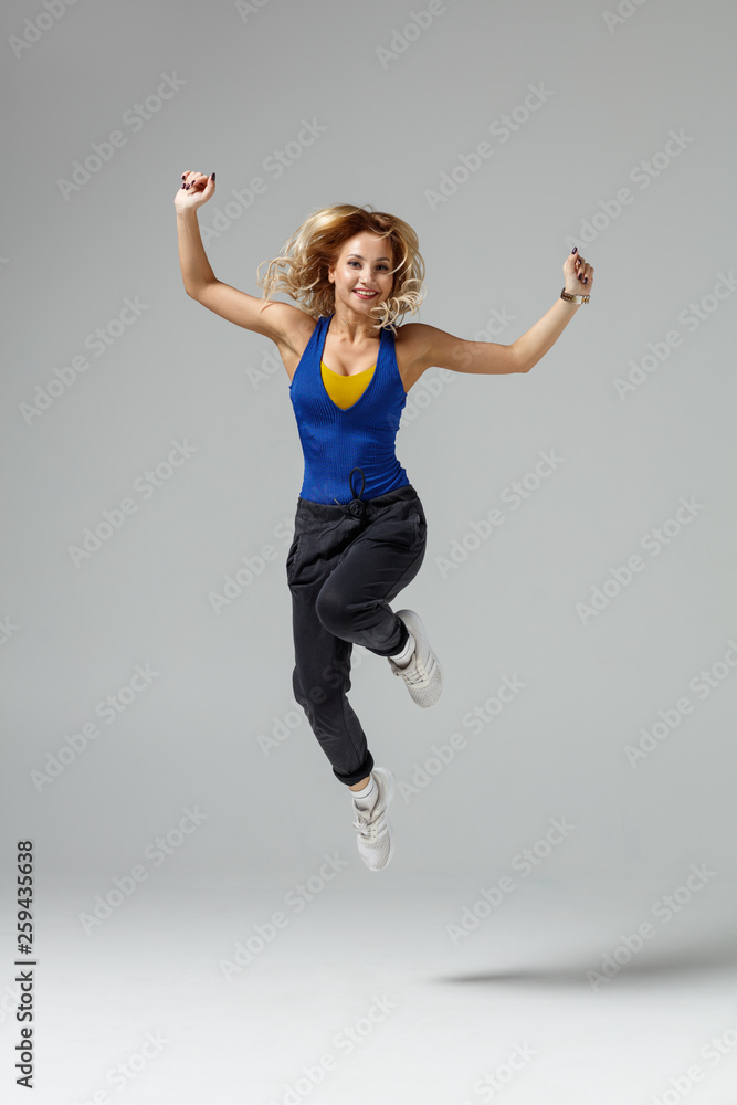 Hip hop dancer moving and jumping in photostudio Hip hop dancer moving and jumping in photostudio