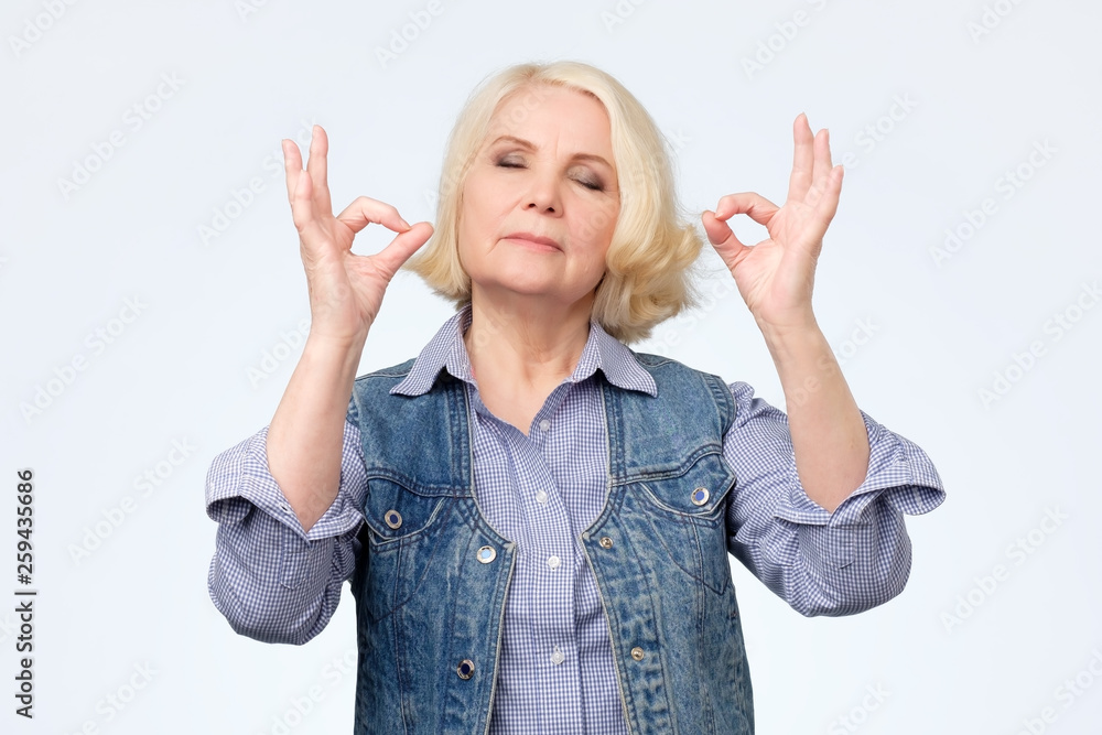 Senior woman doing meditation gesture with fingers Senior woman doing meditation gesture with fingers