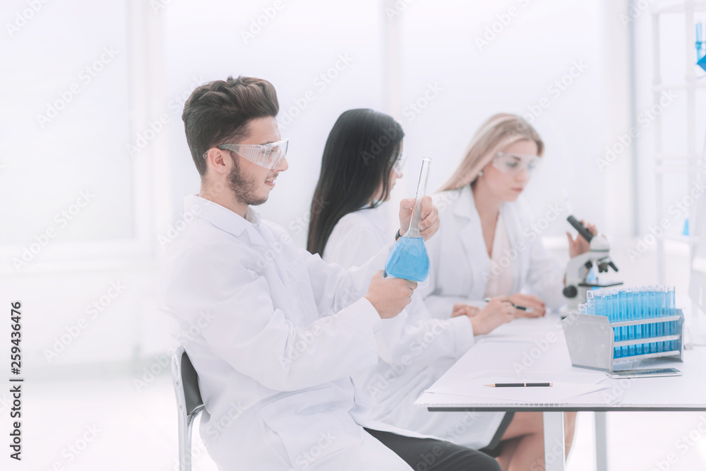 group of scientists examines the liquid in the laboratory group of scientists examines the liquid in the laboratory