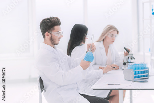 group of scientists examines the liquid in the laboratory