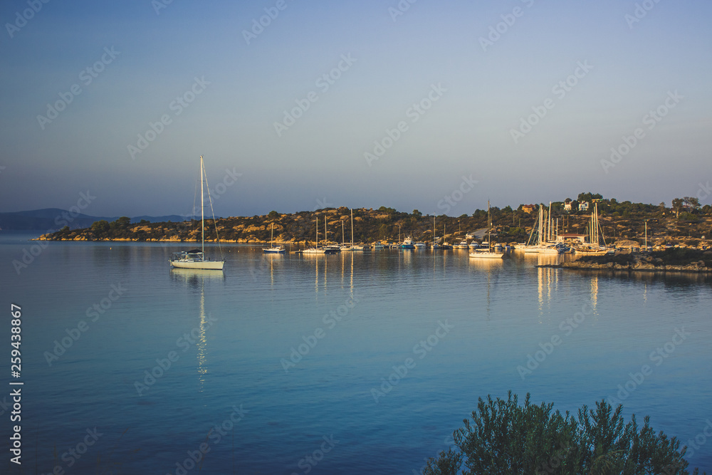 calming outdoor summer evening environment of cozy sea bay with yacht boats on water surface Greece south Europe scenic landscape 