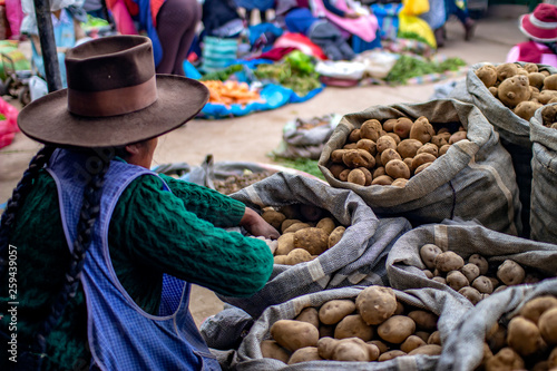 Cusco, Peru - March 31 2019: Indigenous woman selling different types of potatoes at 