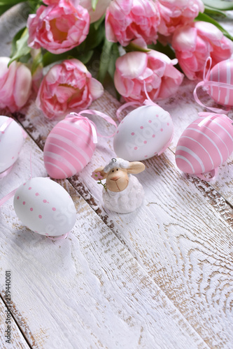 easter decoration with painted eggs and pink tulips