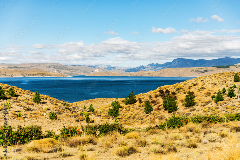 Beautiful landscape photo of turquoise aquamarine lake water and colorful yellow steppes in the mountains of Patagonia, Argentina