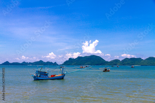 Beach with fishing boat idyllic blue sky at Baan Koh Teap photo