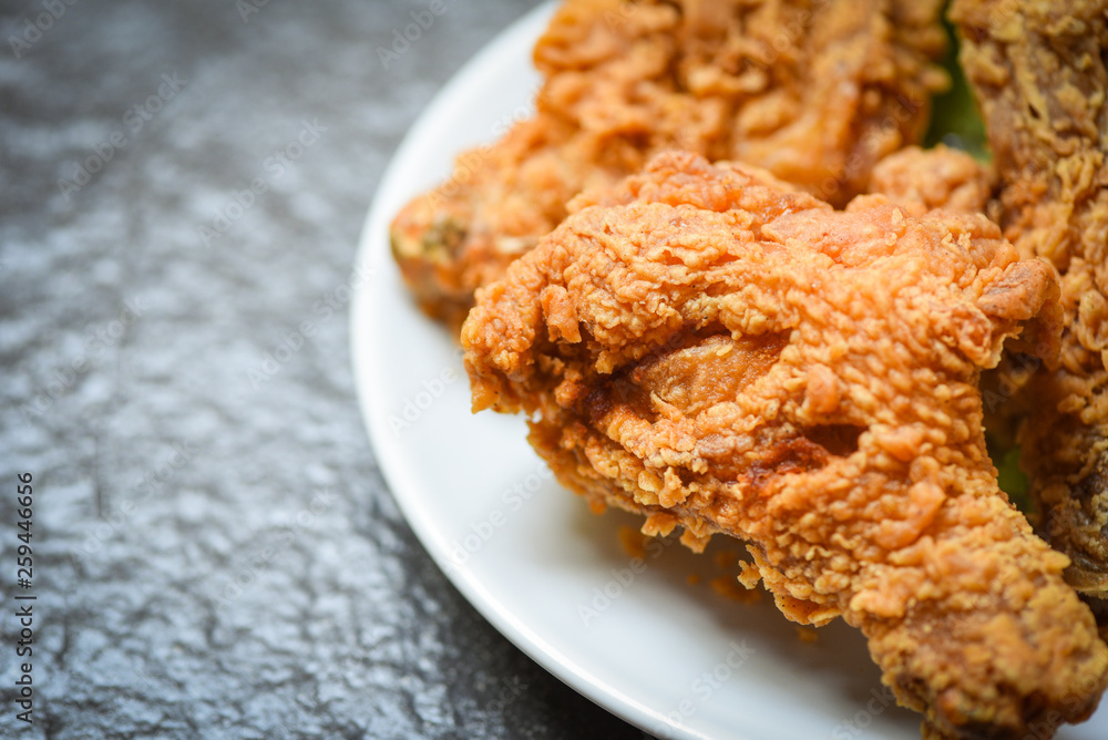 Fried chicken crispy on white plate on dark background Fried chicken crispy on white plate on dark background