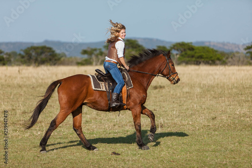 Attractive young blonde woman riding her horse © jacojvr