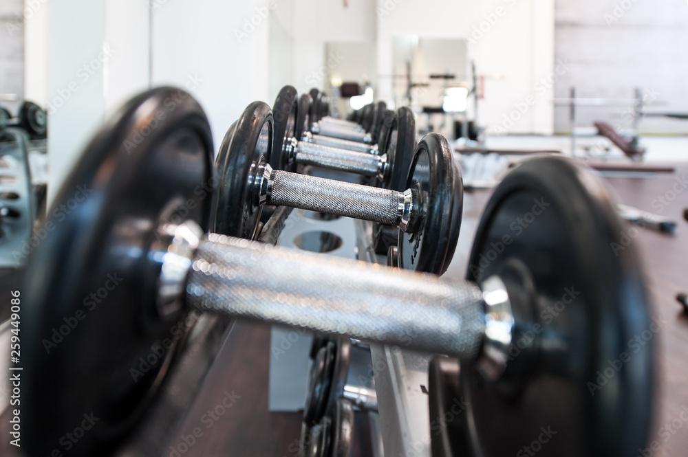 Fototapeta premium Multiple iron dumbbells in sport center