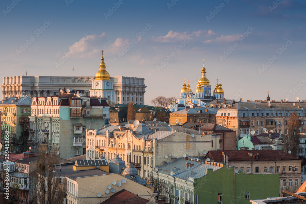 Fototapeta premium Golden dome with a cross on the tower. Church in Kiev at sunset. Temple in the city at sunset.