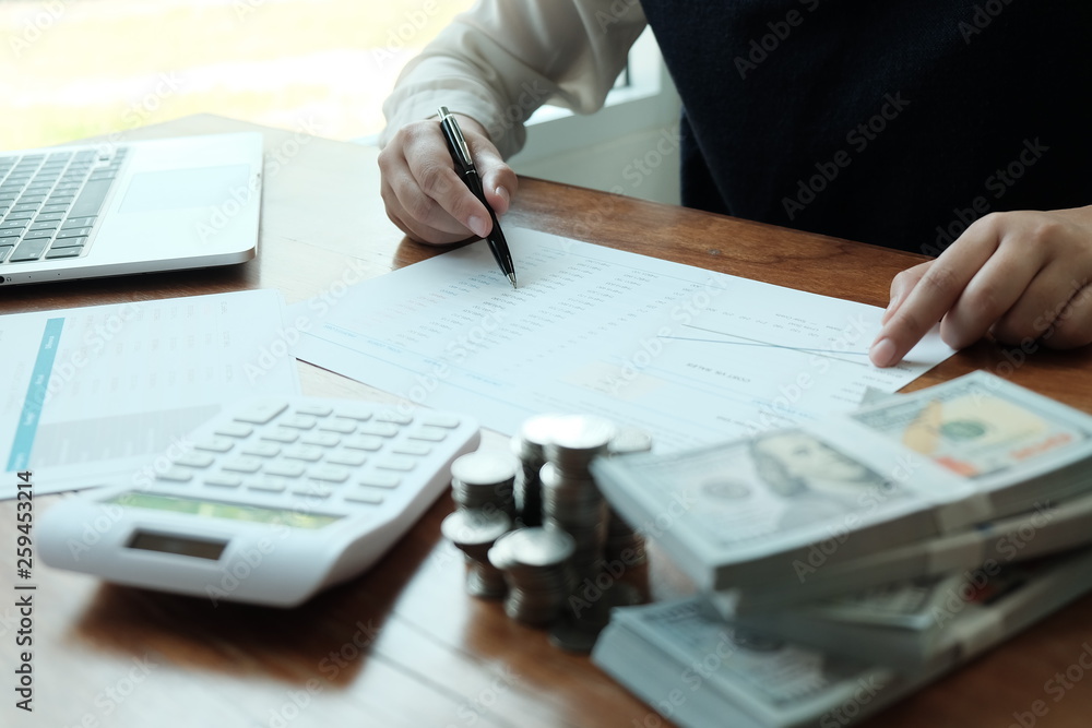 Businessman analyzing investment charts and pressing calculator buttons over documents. Accounting Concept Saving Economy concept. Businessman analyzing investment charts and pressing calculator buttons over documents. Accounting Concept Saving Economy concept.