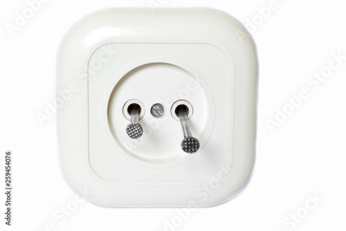 Concept accident prevention - to shove metal nails in the hole of electrical outlet on white background. Isolated. Front view photo