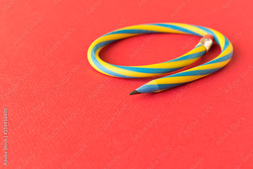 Flexible pencil . Isolated on red background. Bending pencil. Flexible pencil . Isolated on red background. Bending pencil.