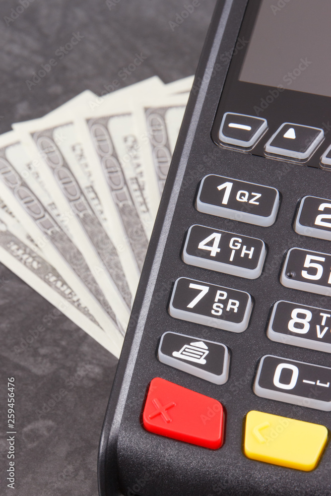 Payment terminal and curriencies dollar. Cashless or cash paying for shopping concept Payment terminal and curriencies dollar. Cashless or cash paying for shopping concept