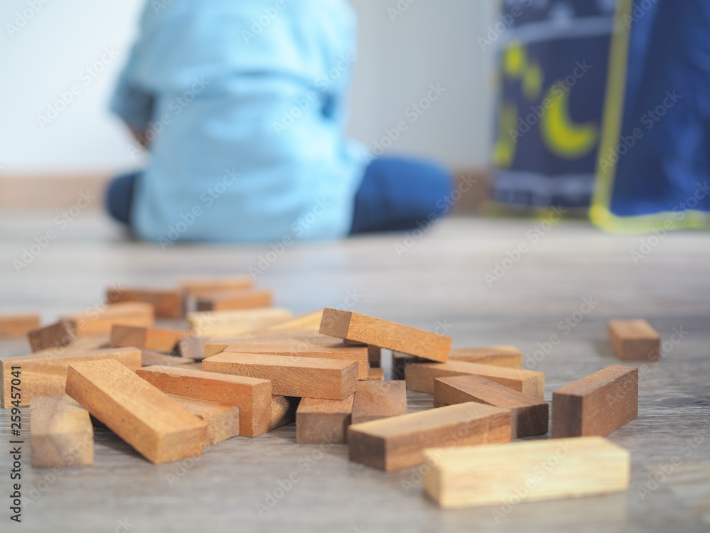 Close up of wooden blocks on the floor with kid background Close up of wooden blocks on the floor with kid background