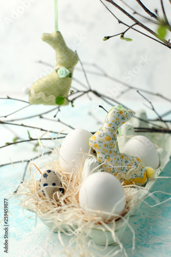 Fototapeta Naklejka Na Ścianę i Meble -  Easter scene with spring fresh greenery branches, rabbit and box of eggs, springtime festive background