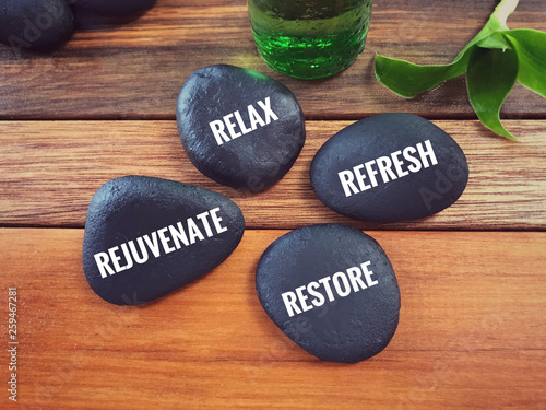 Motivational and inspirational words - Relax, Refresh, Rejuvenate, Restore written on pebbles.