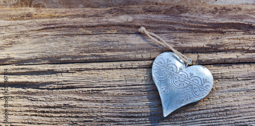 decorative metal heart shaped on a rustic wooden background