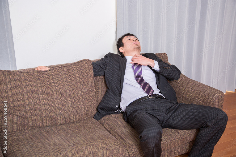 ソファでぐったりする男性 Stock Photo | Adobe Stock