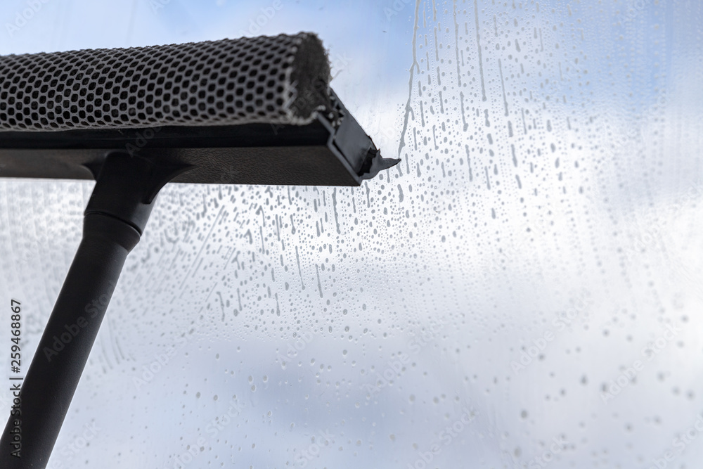 A special window cleaner cleans the foamy liquid from the glass surface.