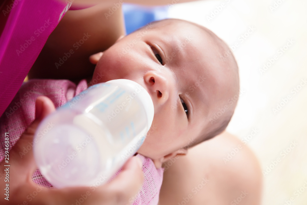 Mother feeding newborn baby boy with milk in nursing bottle. Mother feeding newborn baby boy with milk in nursing bottle.