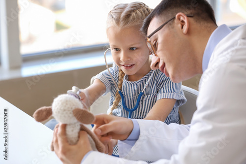 Pediatrician with toy showi...