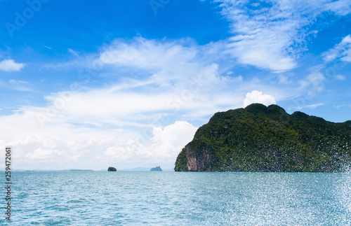 Tropical island near Koh Lanta, Krabi Thailand with water splash from speed boat