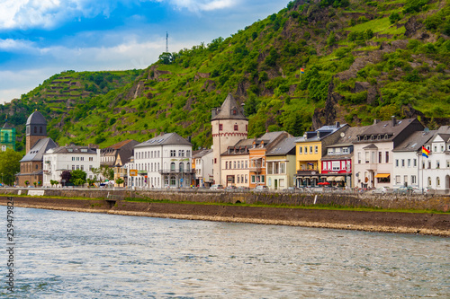 Great townscape view of the town Sankt Goarshausen on the eastern shore of the Rhine River in the German state Rhineland-Palatinate. The medieval round clock tower stands out in the historic district.