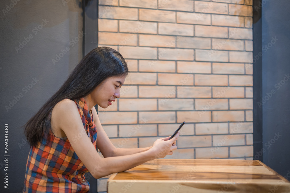 asian women sitting follow social news online with smartphone. he smile happily. asian women sitting follow social news online with smartphone. he smile happily.