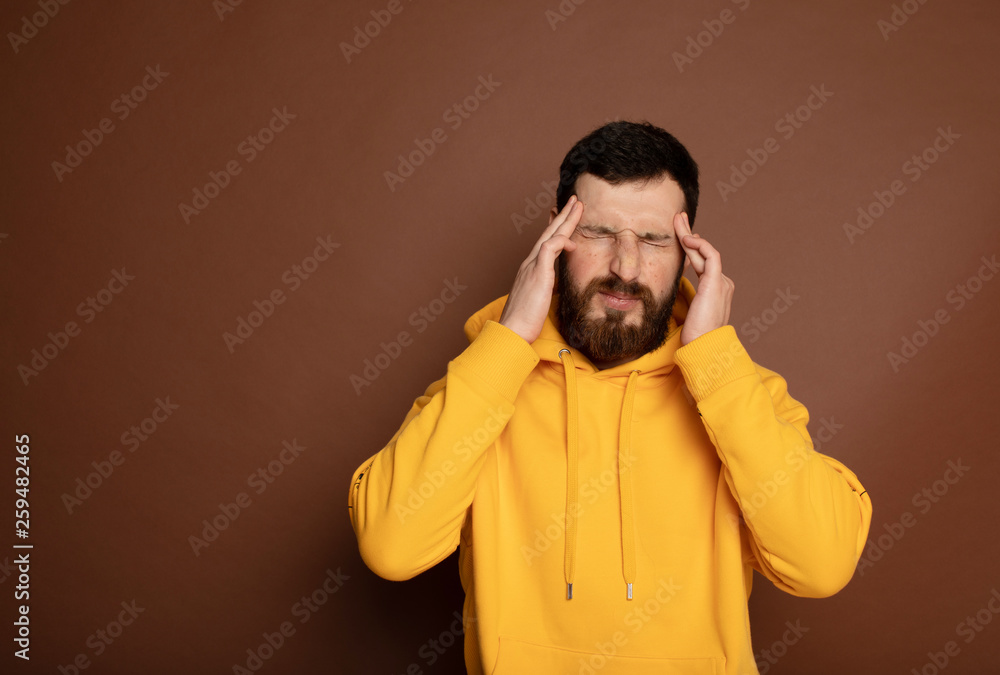 Young sad thoughtful man having headache after work. Young sad thoughtful man having headache after work.