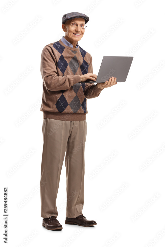 Elderly man standing with a laptop and looking at the camera
