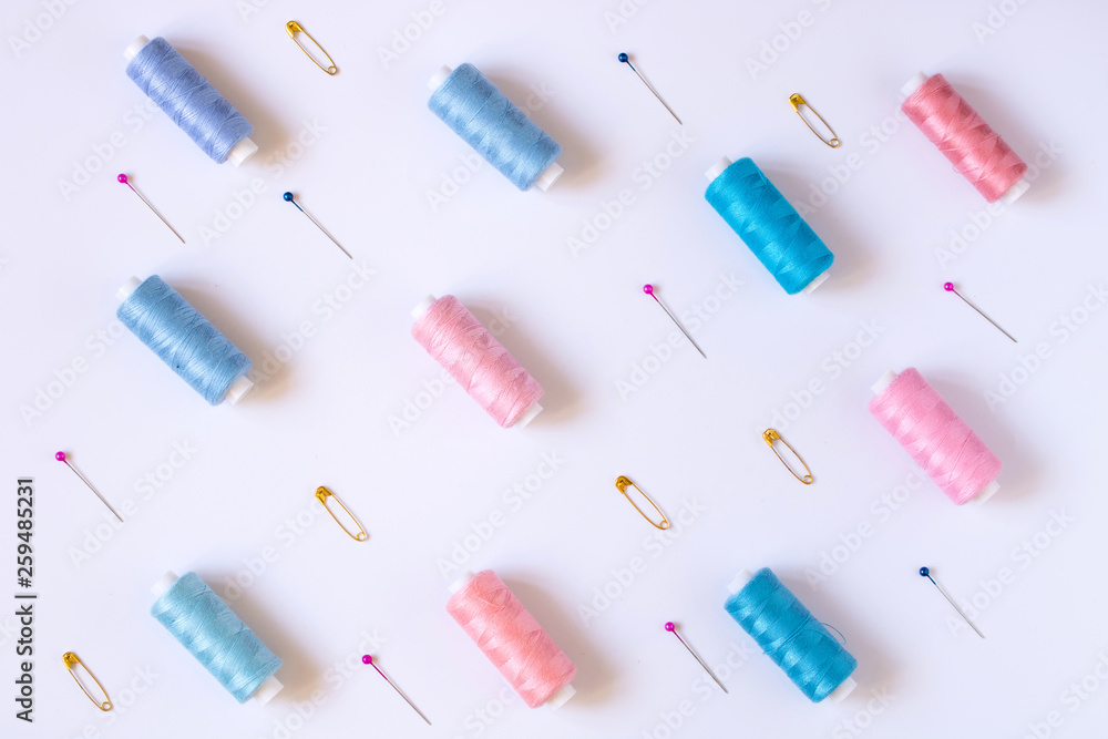 Sewing accessories for needlework in pink and purple and blue tones on white background Sewing accessories for needlework in pink and purple and blue tones on white background