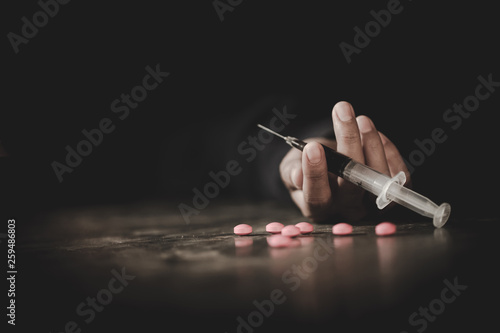 A crazed drug addict reaches for another dose of the drug in the syringe. Guy addicted, The concept of anti drugs. male drug addict, drug syringe.